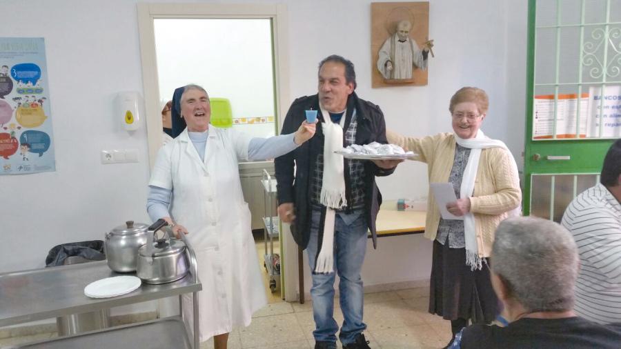 Hijas de la Caridad en una celebración junto a un usuario del comedor social que regentan en la barriada la Palma