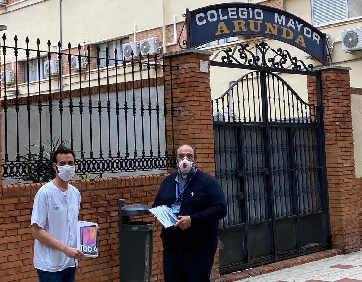 Uno de los enfermeros recibe la tablet para los mayores de manos de Antonio Sosa 