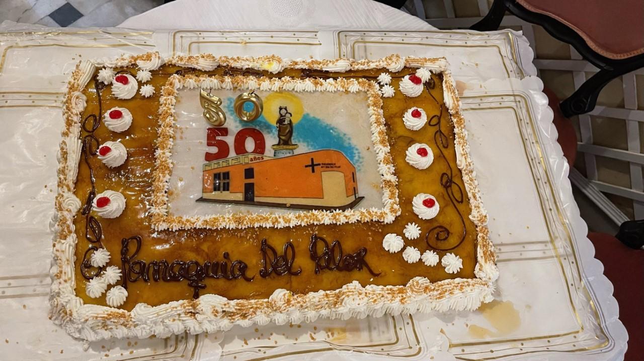La tarta, postre de la comida, llevaba el logo del cincuentenario de la parroquia