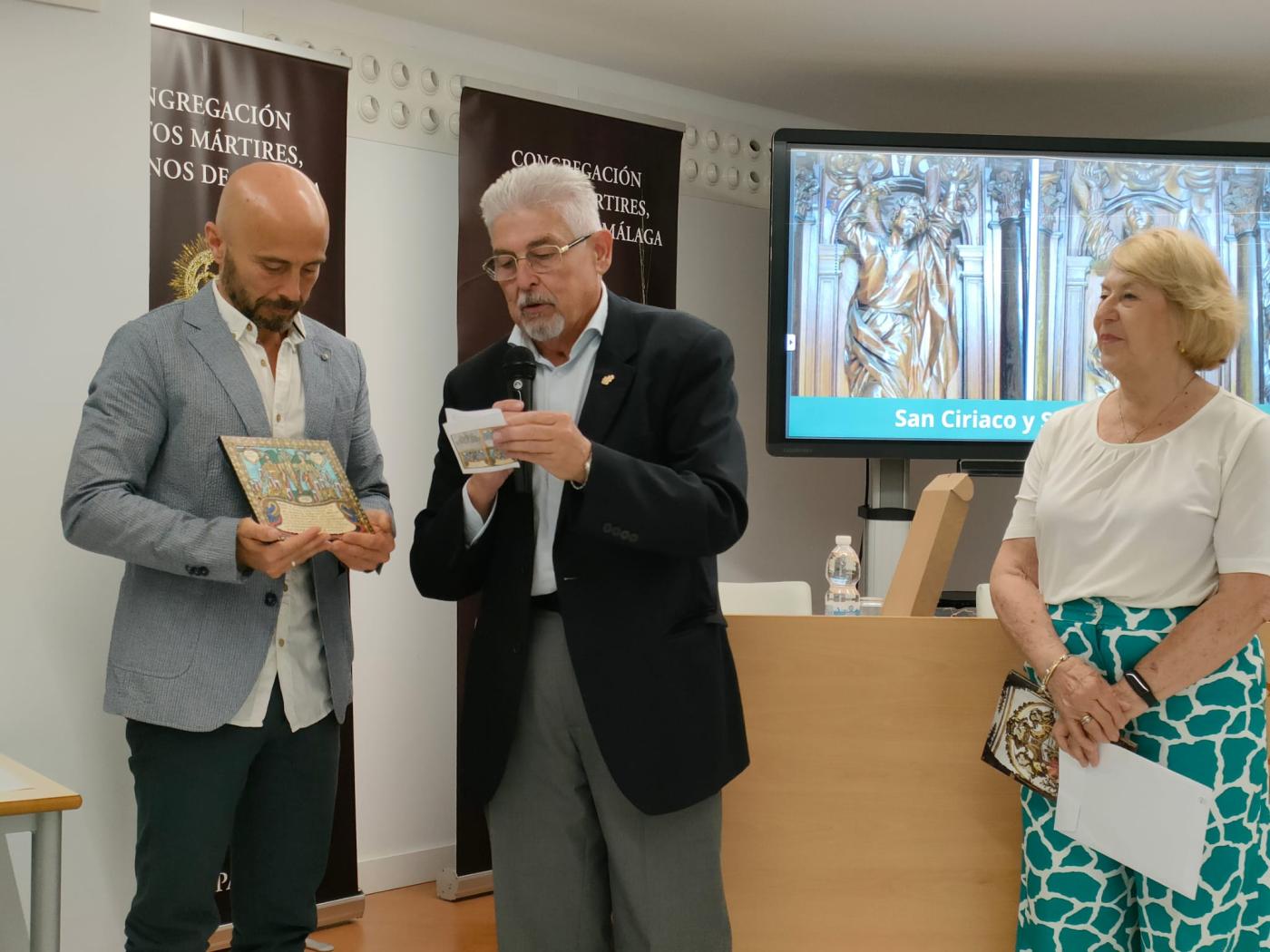 Ángel Nuño recibe un exvoto de los santos patronos de manos del Hermano Mayor, Antonio Ortega / A. MEDINA