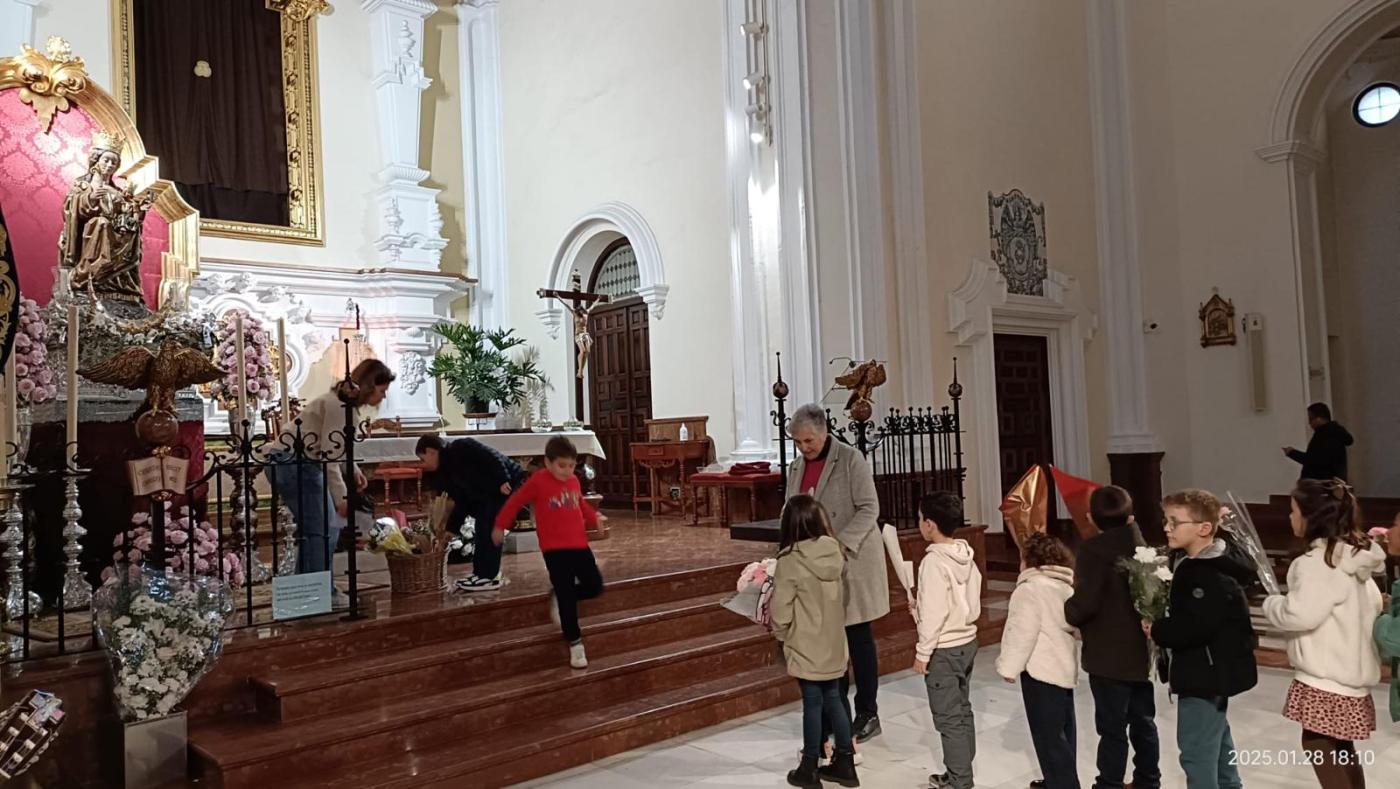 Grupo de Cáritas de El Carmen, ante la Virgen, con el párroco, José Manuel Caselles