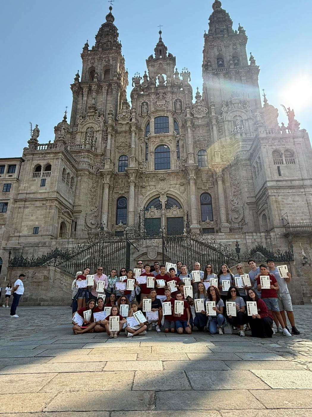Peregrinos de "Gente de San Juan", de la parroquia de San Juan Bautista de Vélez-Málaga, muestran su credencial de peregrino, la célebre "compostela"
